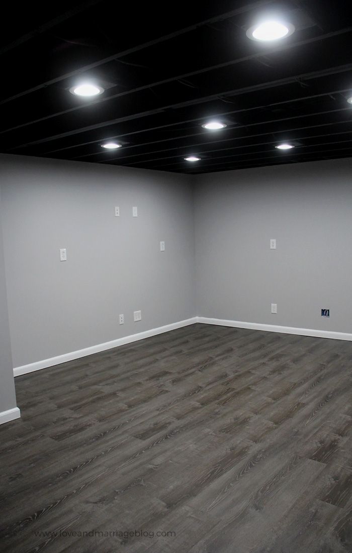 an empty room with white walls and wood floors is lit by recessed light bulbs