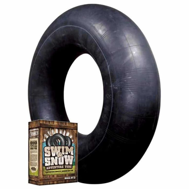 a large black tire sitting on top of a white wall next to a package of gum