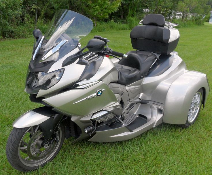 a silver motorcycle parked on top of a lush green field