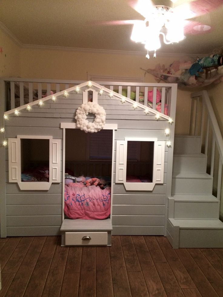 a child's bedroom with bunk beds, stairs and lights on the ceiling above