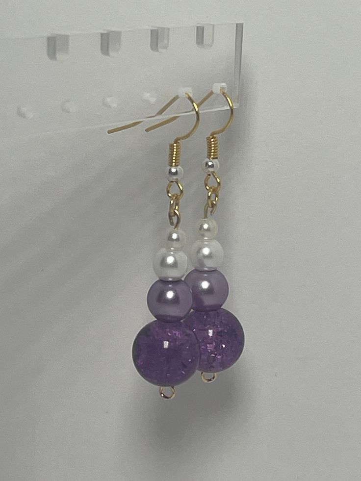 Add a touch of elegance to your jewelry collection with these stunning beaded earrings featuring a purple crystal like bead and a white pearl like bead. The combination of the deep purple hue and the classic white creates a timeless look that can be dressed up or down. The dainty size of the white pearl adds a delicate touch to the overall design, making these earrings a versatile accessory for any outfit. Handcrafted with care, these earrings are sure to make a statement wherever you go. Elegant Purple Crystal Earrings With Dangling Beads, Elegant Lavender Beaded Earrings With Dangling Beads, Purple Crystal Earrings With Round Beads For Gift, Elegant Purple Beaded Earrings With Faceted Beads, Elegant Purple Earrings With Dangling Beads, Elegant Lavender Beaded Drop Earrings, Purple Dangling Round Bead Earrings, Purple Dangling Bead Earrings, Purple Dangling Beads Earrings