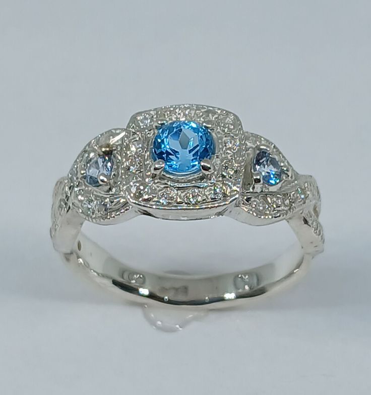 This stunning  style ring has been carefully crafted in 925 solid sterling silver (not silver plated), blue  topaz stone and cubic zirconia.  This beautiful ring would make a great special occasion/birthday gift All of my jewelry is handmade from scratch and of high quality. A tracking shipping number will be provided to you once ring has been mailed. Ring Measurements: Ring is size 7 1/2 but can be resized at no extra cost and will be shipped to you in an elegant gift box. Ring Weight: 3.7 gram Blue Topaz Ring In 14k White Gold, Dazzling Sterling Silver Topaz Ring For Anniversary, Blue Cubic Zirconia Promise Jewelry, Fine Jewelry Topaz With Halo Design, Diamond White Aquamarine Rings For Anniversary, Silver Blue Topaz Diamond Ring As Gift, Classic Blue Halo Ring With Accent Stones, Gift Blue Topaz Diamond Ring In Silver, Blue Topaz Diamond Promise Ring