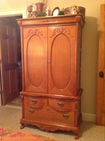 a wooden armoire sitting in the corner of a room