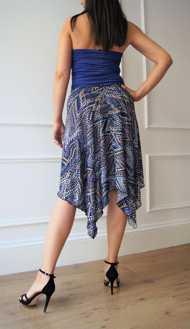 "Add a touch of elegance to your summer clothing collection with our patterned skirt, entirely handmade. The skirt features a longer tail at the back and a shorter cut in the front, with an elastic waistband for a comfortable and snug fit. Made with high-quality, Italian fluid jersey fabric, the skirt is perfect for tango, milonga, and also for a day-time look. Buy your unique and versatile summer skirt today! Size: S-M Front length: 56 cm Back length: 86 cm Waist circumference: 66-72 cm The mod Elegant Flowy Skirt With Handkerchief Hem, Summer Asymmetrical Hem Pleated Draped Skirt, Summer Pleated Draped Skirt With Asymmetrical Hem, Summer Draped Pleated Tiered Skirt, Summer Stretch Asymmetrical Maxi Skirt, Fitted Handkerchief Hem Wrap Skirt, Fitted Flared Wrap Skirt For Beach, Chic Fitted Draped Summer Skirt, Chic Fitted Draped Skirt For Summer