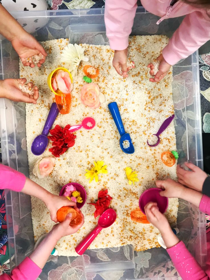 several children are playing with toys in a plastic container