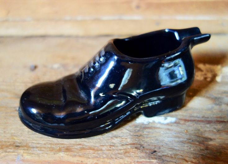 a black shoe sitting on top of a wooden table