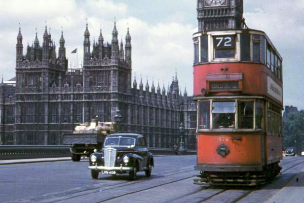 an old fashioned double decker bus driving down the street in front of big ben and parliament