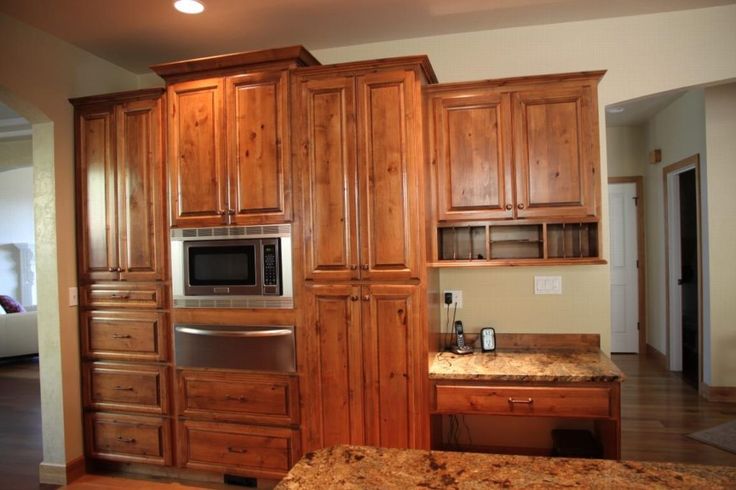 a kitchen with wooden cabinets and granite counter tops, stainless steel appliance and microwave