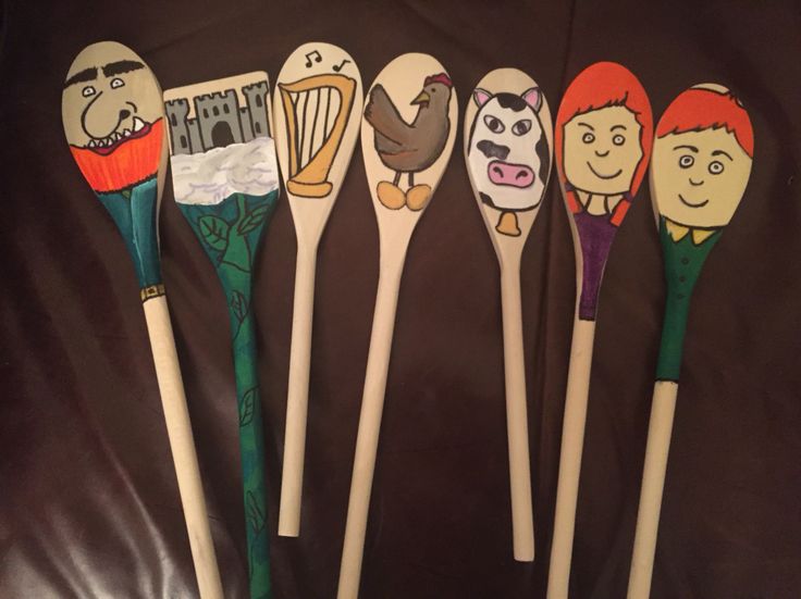 five spoons with cartoon characters on them are lined up in a row against a brown background