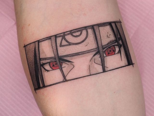 a woman's arm with a tattoo on it that has two red eyes in the middle