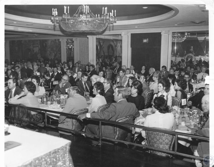 a large group of people sitting at tables in a room