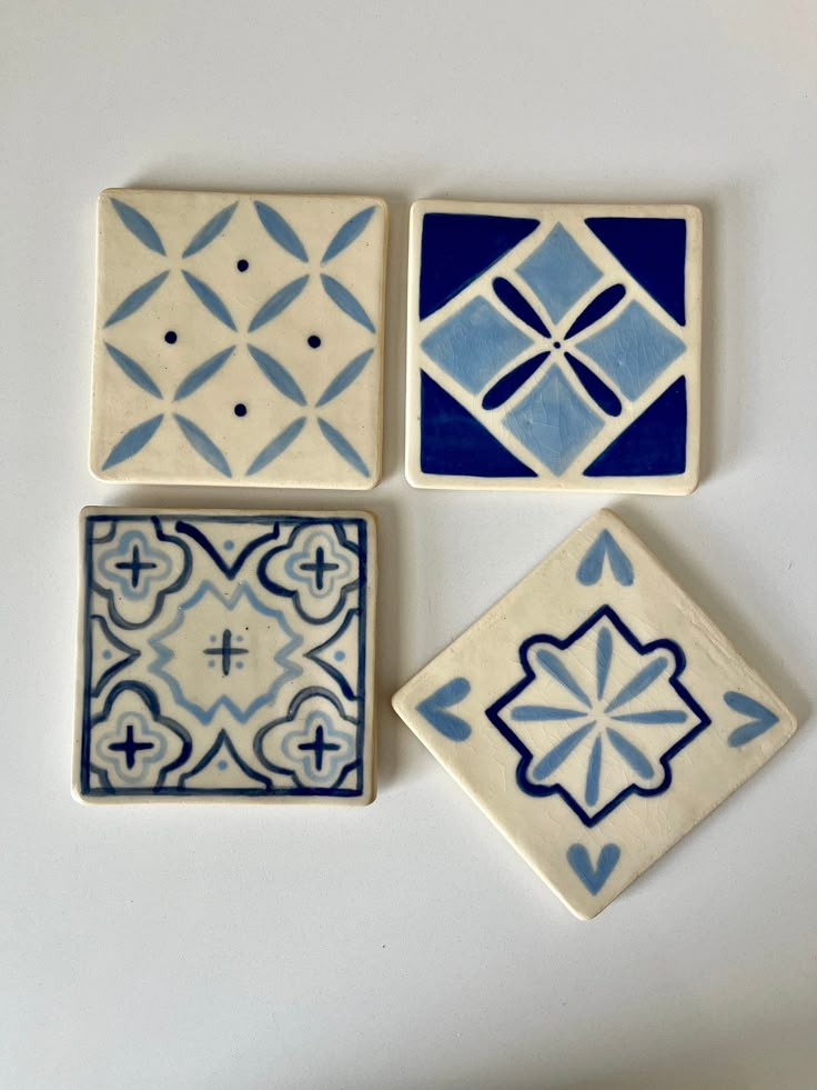 four blue and white tiles on a table