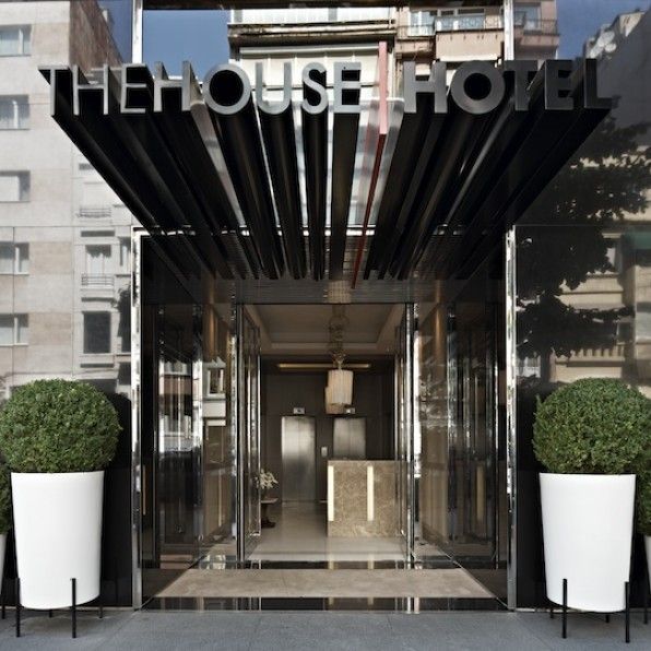 an entrance to a hotel with potted plants on either side and the words, the house hotel above it