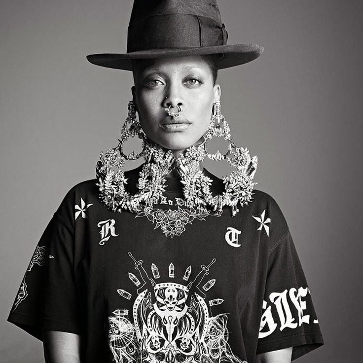 a black and white photo of a woman wearing a shirt with an elaborate necklace on her neck