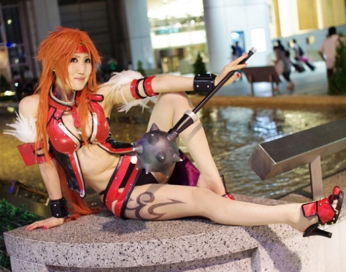 a woman dressed in cosplay clothing sitting on a wall next to a fountain