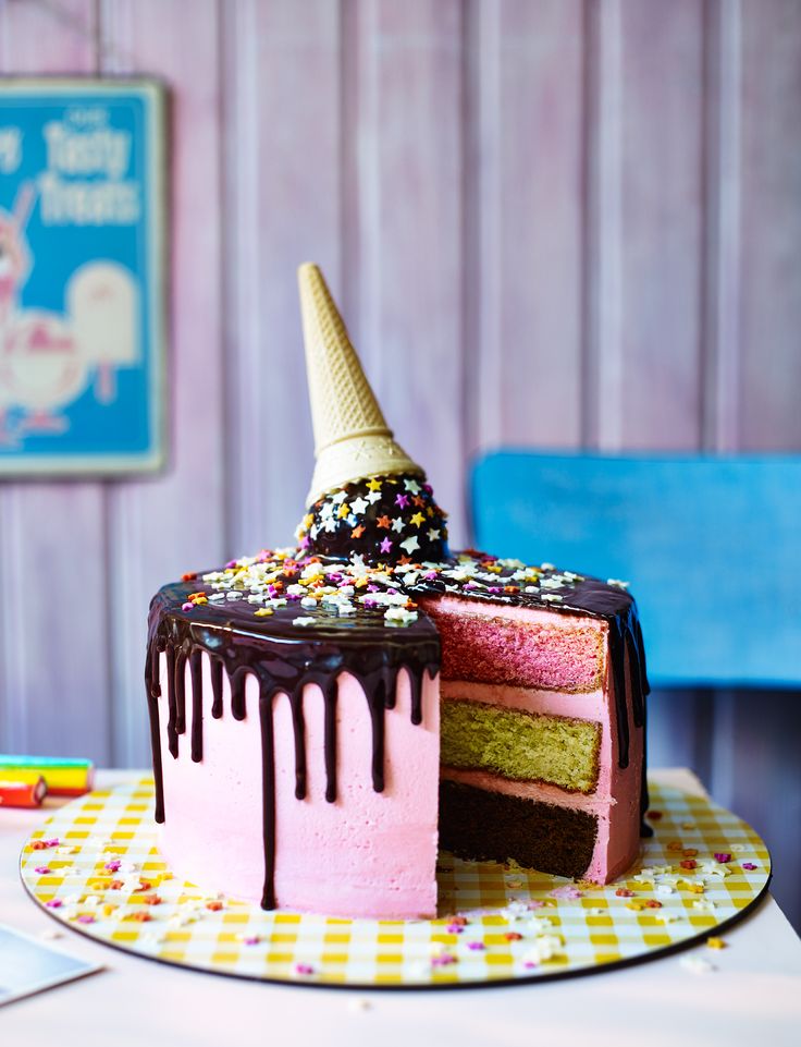 a birthday cake with chocolate icing and sprinkles on top, sitting on a table