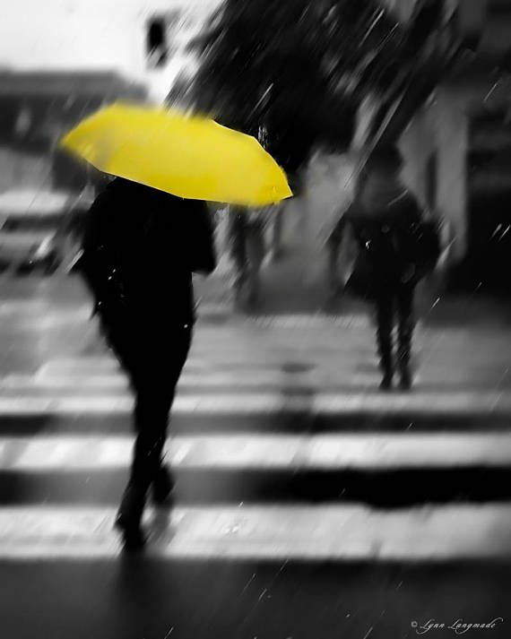 a person walking across a street holding an umbrella