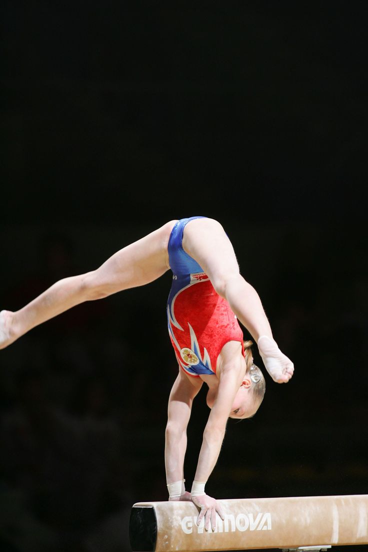 a person on a balance beam doing a handstand