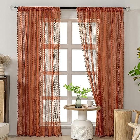 a living room with orange curtains and a white table