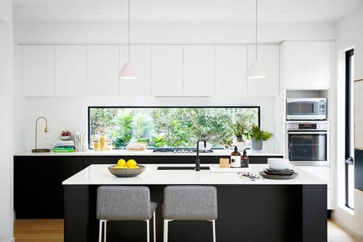 a kitchen with two stools next to an island