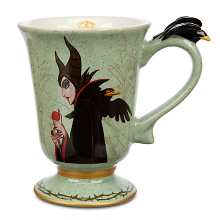 a ceramic cup with an image of a witch on the side and a bird perched on top