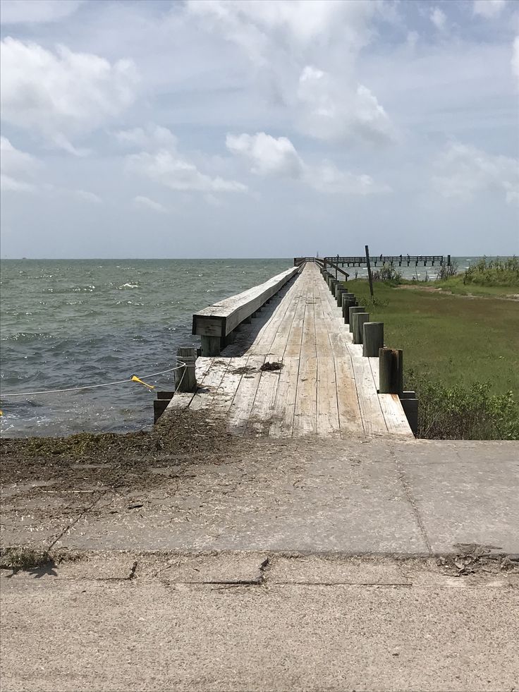 a long wooden pier stretching out into the ocean