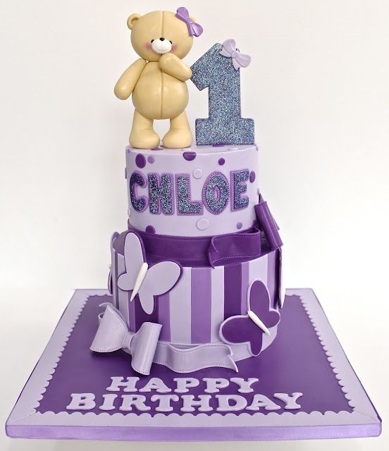 a purple and white cake with a teddy bear on top