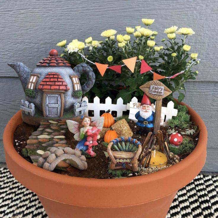 a potted plant with gnomes and flowers in it