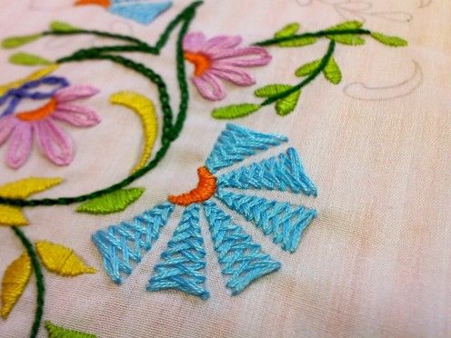 an embroidered design with flowers on it