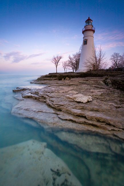 a light house sitting on top of a cliff next to the ocean