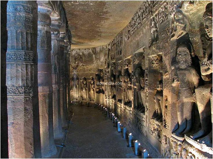 the interior of an ancient building with sculptures on it's walls and columns in front of them