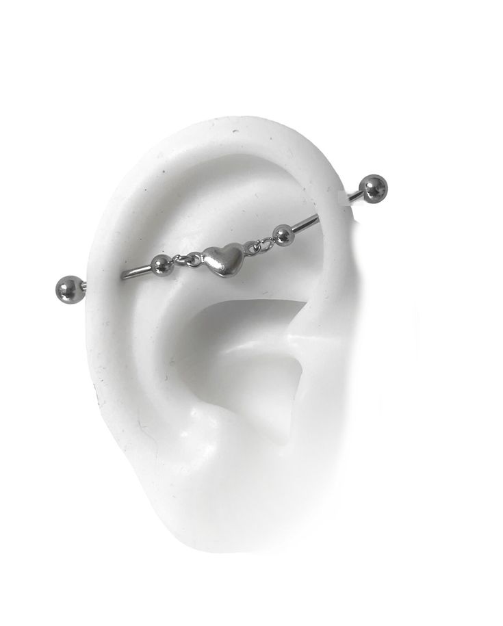 a pair of ear piercings sitting on top of a white object in the shape of an ear