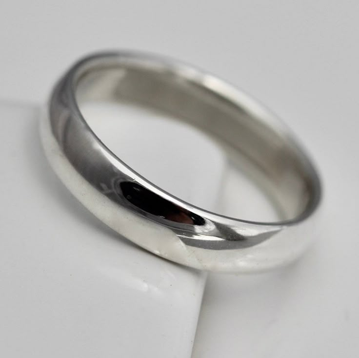 a close up view of a wedding ring on a white surface with a black diamond in the center