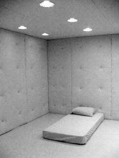 an empty room with a mattress and lights