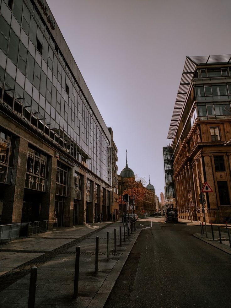 an empty city street with tall buildings in the background