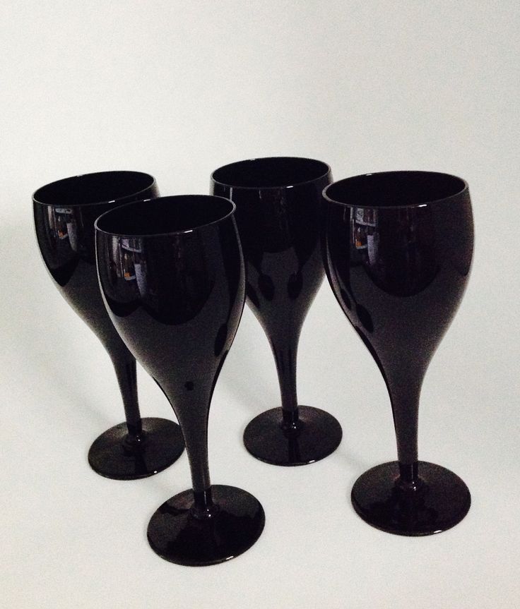 four black wine glasses sitting next to each other