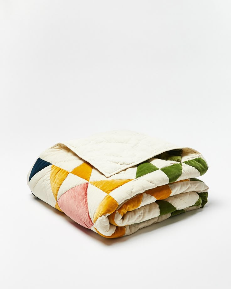 a blanket is folded on top of each other with multicolored squares in the middle