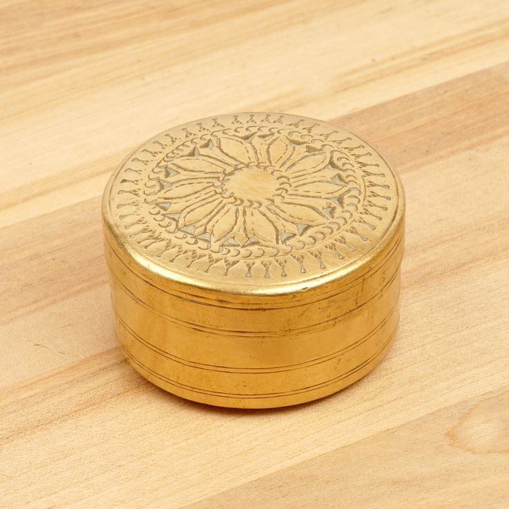 a small gold box sitting on top of a wooden table