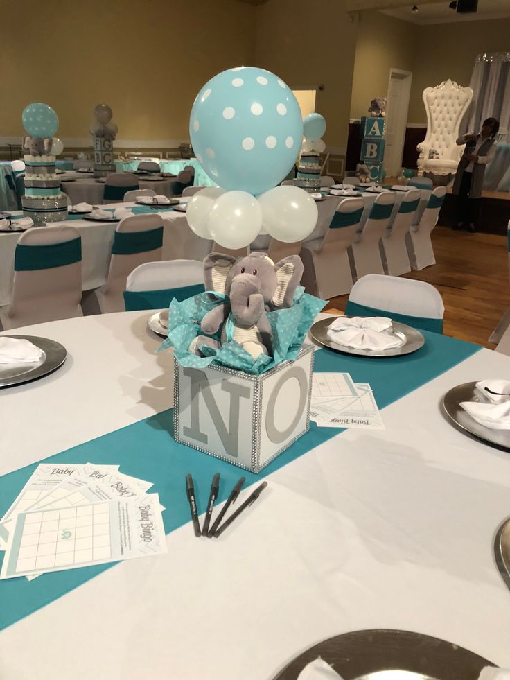 a table set up for a baby's first birthday with blue and white decorations