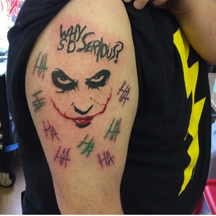 a man with a tattoo on his arm that reads why serious? and has the joker face painted on it