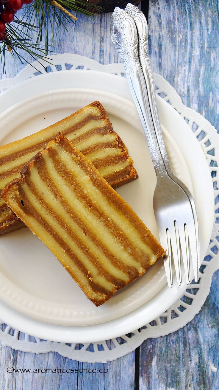 two slices of cake sitting on top of a white plate next to a fork and knife