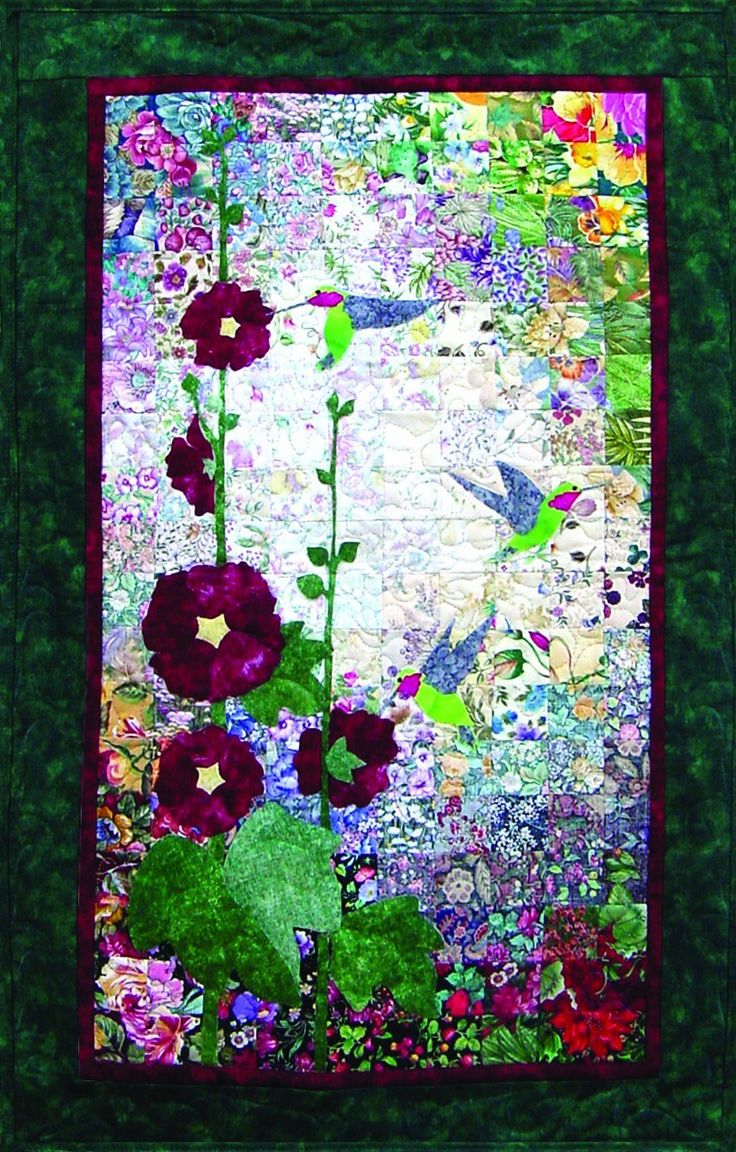 a quilted wall hanging with red flowers and birds in the background on green fabric