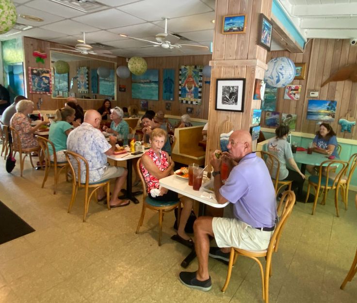 several people sitting at tables in a restaurant