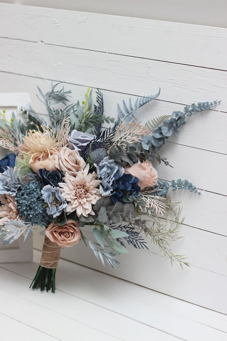 a bridal bouquet with blue and pink flowers