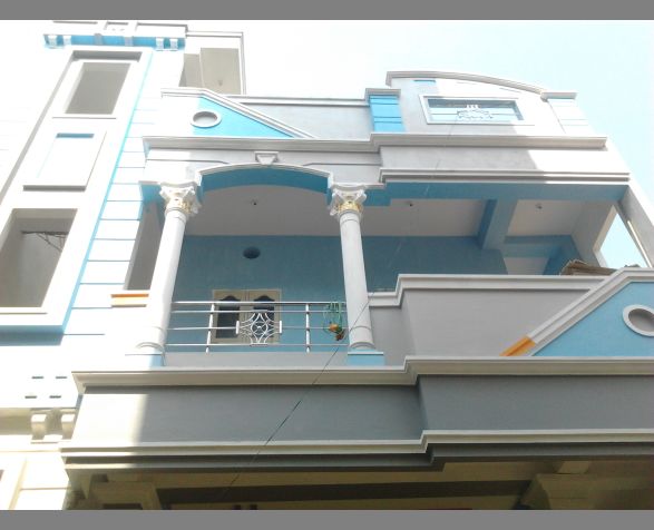 a blue and white building with two balconies on the second floor, and a balcony