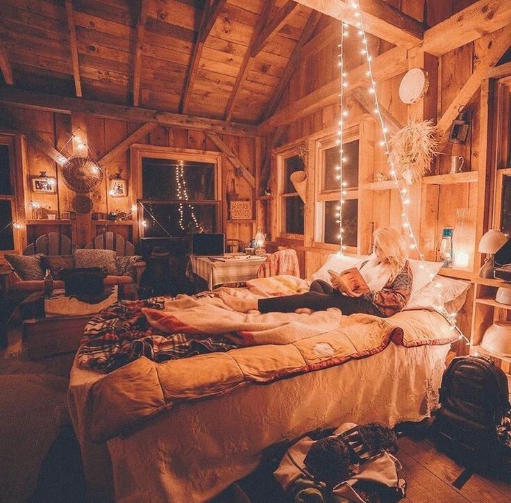 a bed room with a neatly made bed and lots of lights hanging from the ceiling