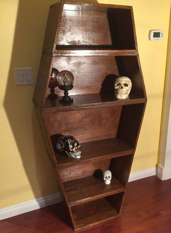 a wooden book shelf with skulls on it