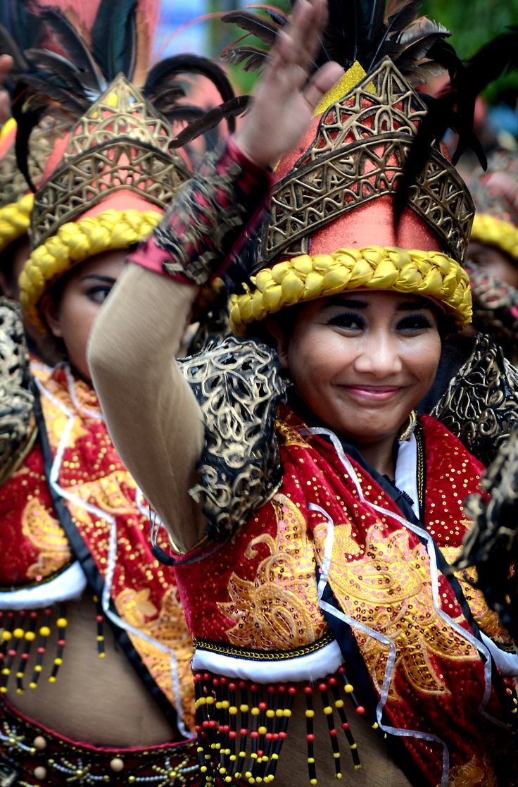 a group of women in colorful costumes standing next to each other with their hands up