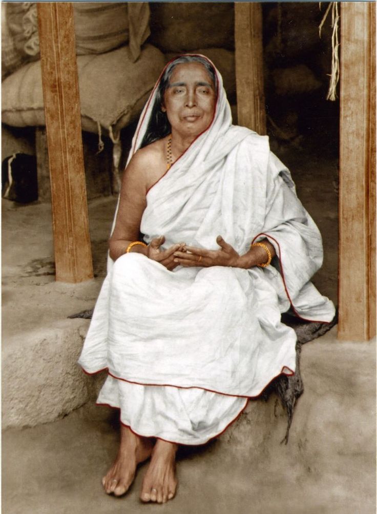 an old photo of a woman sitting on the ground