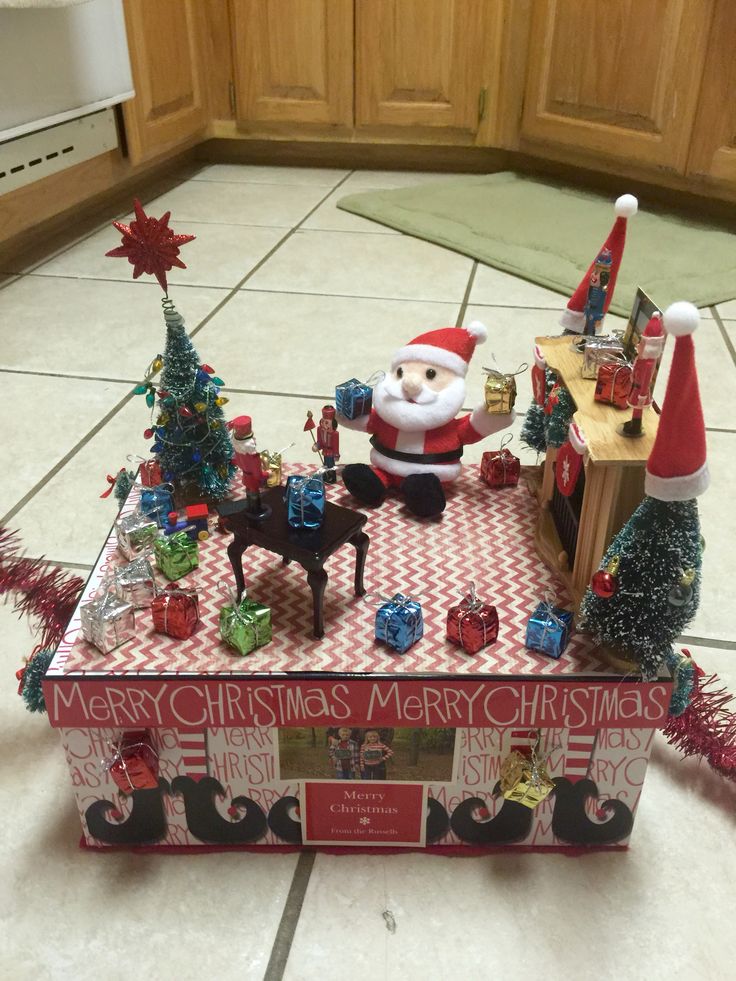 a santa clause is sitting on top of a table with christmas decorations and gifts in it